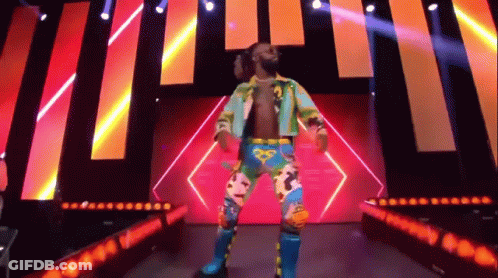 A Wrestler Is Standing On A Stage In Front Of A Crowd . GIF