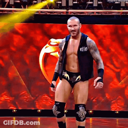A Wrestler Is Standing On A Stage With A Ring In The Background .. GIF