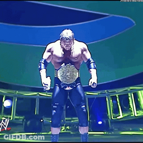 A Wrestler Is Standing On A Stage With A Wwe Logo In The Background GIF