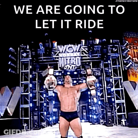 A Wrestler Is Standing On A Stage With His Arms Outstretched And A Sign That Says We Are Going To Let It Ride GIF