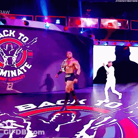 A Wrestler Is Walking Through A Tunnel With The Words Back To Dominate On The Wall Behind Him GIF