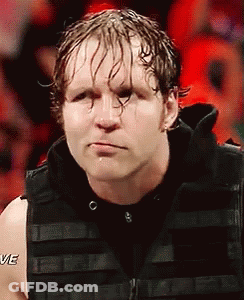 A Wrestler Is Wearing A Black Vest And Making A Funny Face While Standing In Front Of A Crowd . GIF
