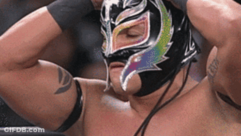 A Wrestler Is Wearing A Mask With A Rainbow Design On His Face . GIF