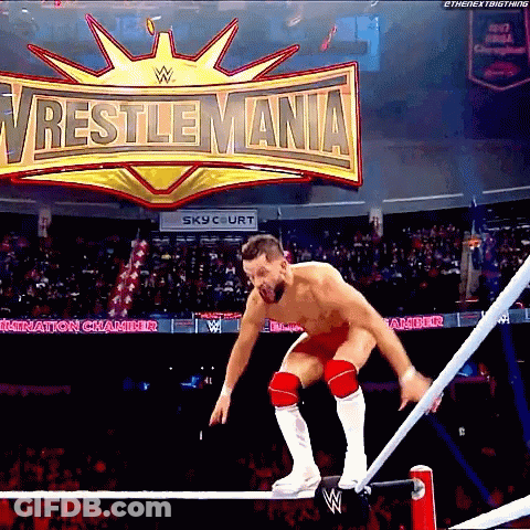 A Wrestler Jumps Over A Rope In Front Of A Wrestlemania Sign GIF