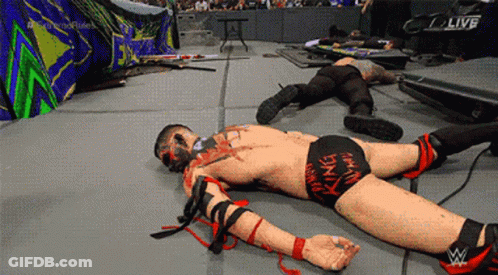 A Wrestler Laying On The Ground With The Word Live On The Screen GIF