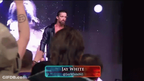 A Wrestler Named Jay White Is Standing In Front Of A Crowd Of People GIF