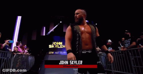A Wrestler Named John Skyler Is Standing In Front Of A Crowd In A Wrestling Ring . GIF