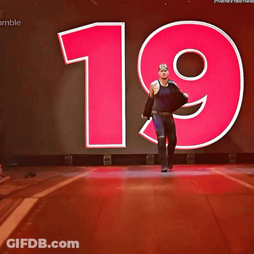 A Wrestler Named King Corbin Walks Down The Aisle In Front Of A Large Number 19 GIF