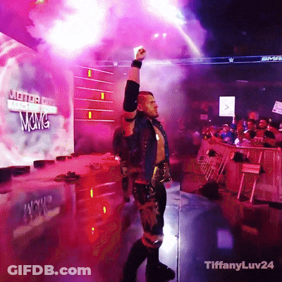 A Wrestler Stands In Front Of A Sign That Says Wwe GIF