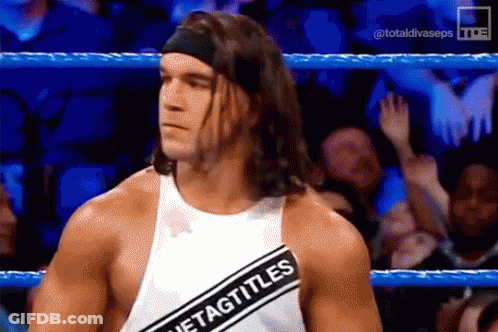A Wrestler Wearing A Headband And A White Tank Top With A Black Stripe That Says Tag Titles GIF
