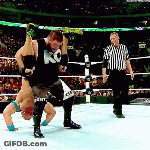 A Wrestler Wearing A Ko Tank Top Is Being Lifted In The Air GIF