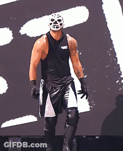 A Wrestler Wearing A Mask And A Black Tank Top With The Word Rumble On The Front GIF
