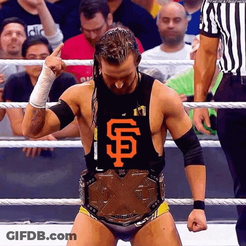 A Wrestler Wearing A San Francisco Giants Shirt Stands In A Ring GIF