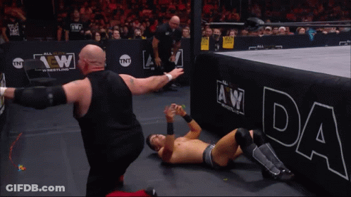 A Wrestler Wearing A Shirt That Says Chaos In Music GIF