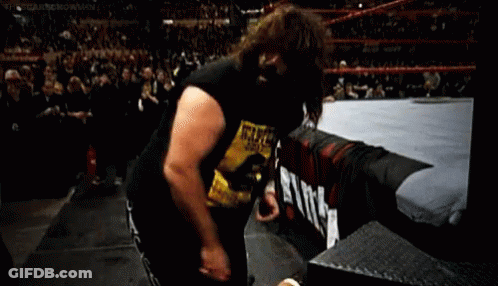 A Wrestler Wearing A Wanted Shirt Is Standing In A Ring . GIF