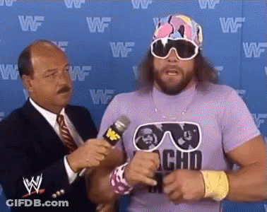 A Wrestler Wearing Sunglasses And A Purple Shirt Is Being Interviewed By A Man In A Suit And Tie . GIF