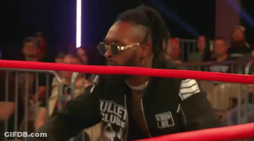 A Wrestler Wearing Sunglasses Is Crawling Through The Ring . GIF