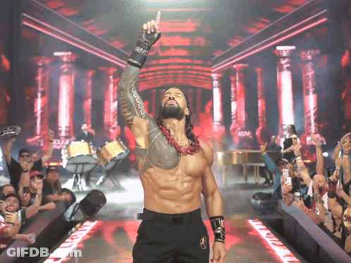 A Wrestler With A Tattoo On His Arm Is Giving A Thumbs Up In Front Of A Crowd GIF