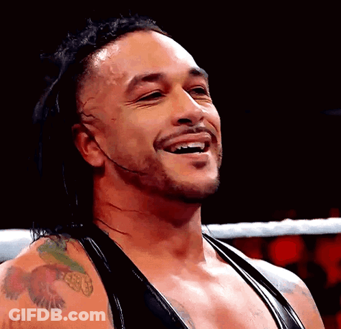 A Wrestler With A Tattoo On His Arm Is Smiling GIF