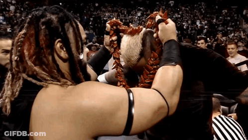 A Wrestler With Dreadlocks Is Holding A Lei Around His Head GIF