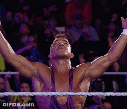 A Wrestler With His Arms Outstretched In The Air GIF