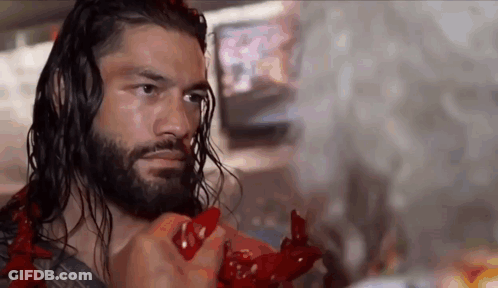 A Wrestler With Long Hair And A Beard Is Holding A Red Object . GIF