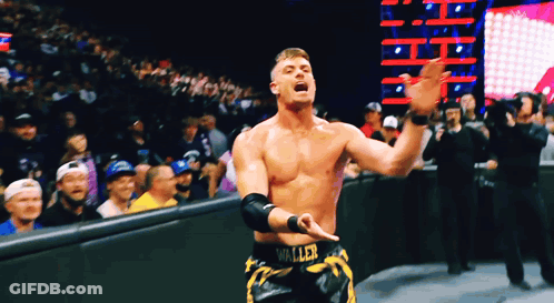 A Wrestler With The Word Waller On His Shorts Stands In Front Of A Crowd GIF
