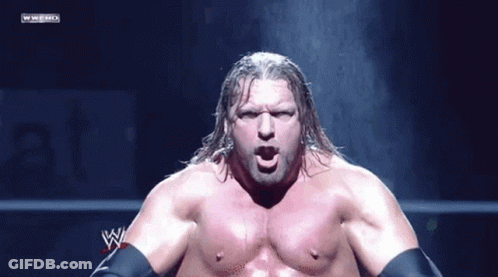 A Wrestler Without A Shirt Is Standing In Front Of A Wwe Logo GIF