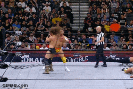 A Wrestling Match Is Taking Place In Front Of A Crowd And The Word Double Is On The Ring GIF