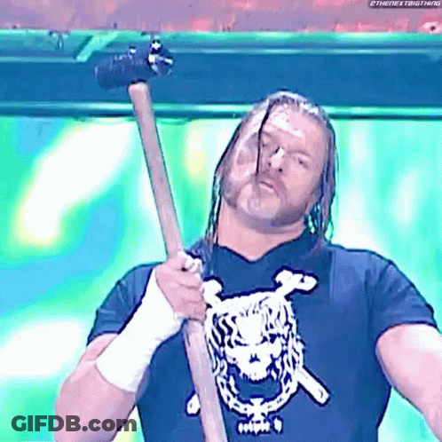 A Wrestling Wrestler Is Holding A Hammer In His Hand . GIF