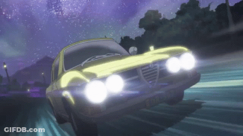 A Yellow Alfa Romeo Is Driving Down A Road At Night With Its Headlights On GIF