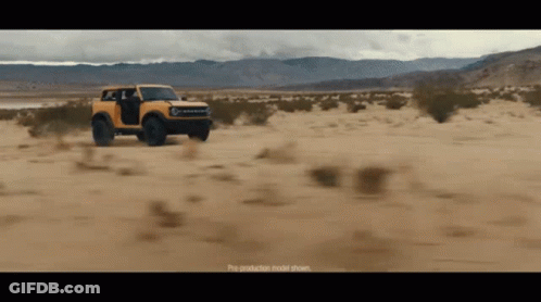 A Yellow Bronco Is Driving Through A Desert GIF