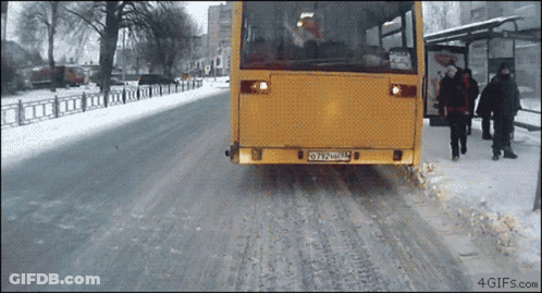 A Yellow Bus With A License Plate That Says Oy27uml Is Driving Down A Snowy Street GIF