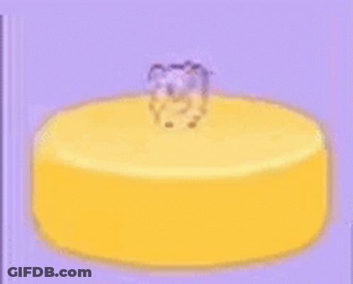 A Yellow Cake With A Teddy Bear On Top Of It . GIF