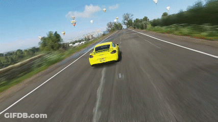 A Yellow Car Is Driving Down A Highway With Hot Air Balloons In The Background GIF