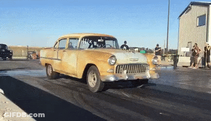 A Yellow Car Is Driving Down A Race Track With The Number 14X On The Windshield GIF