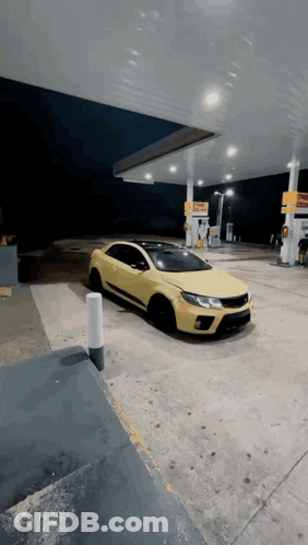 A Yellow Car Is Parked In Front Of A Gas Station GIF