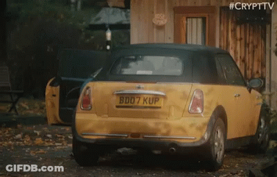 A Yellow Car With The License Plate B007 Kup Is Parked In Front Of A Wooden Building GIF
