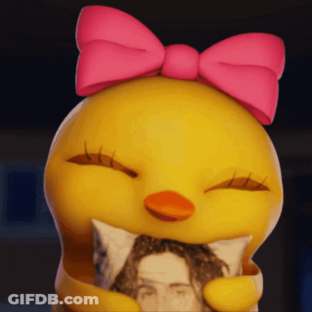 A Yellow Duck With A Pink Bow On Its Head Is Holding A Pillow GIF