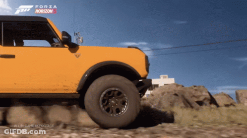 A Yellow Ford Bronco Is Driving Down A Dirt Road In Forza Horizon GIF