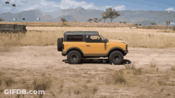 A Yellow Ford Bronco Is Driving Through A Desert GIF