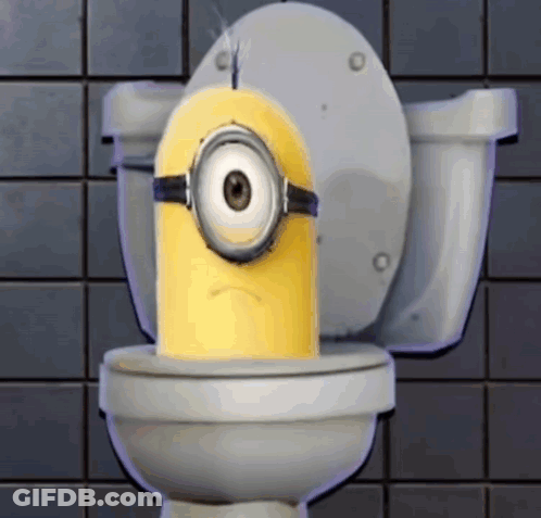 A Yellow Minion Is Sitting On A Toilet With A Sad Look On His Face GIF