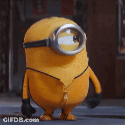 A Yellow Minion Wearing A Yellow Suit And Goggles Is Standing On A Street With His Mouth Open . GIF