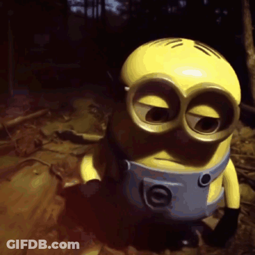 A Yellow Minion With Big Eyes And A Blue Belt Around His Neck GIF