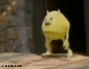 A Yellow Monster From Monsters Inc Is Standing On A Wooden Floor In A Dark Room . GIF