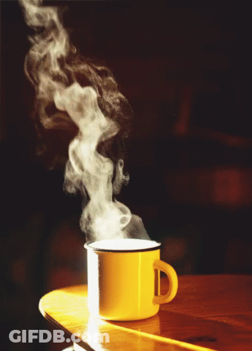 A Yellow Mug With Steam Coming Out Of It Sits On A Table GIF