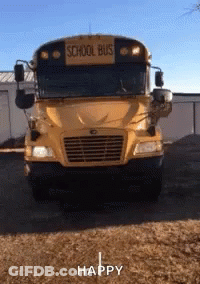 A Yellow School Bus Is Parked In A Dirt Field GIF