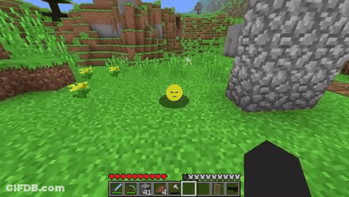 A Yellow Smiley Face Is Sitting In The Grass In A Minecraft World GIF