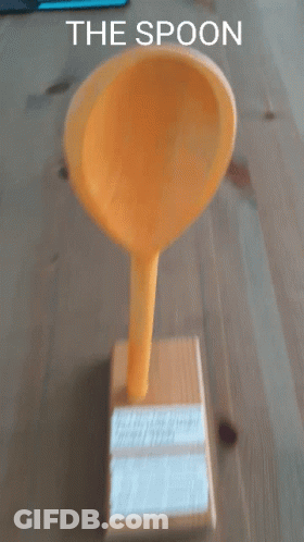 A Yellow Spoon Sitting On Top Of A Wooden Box With The Words " The Spoon " Below It GIF