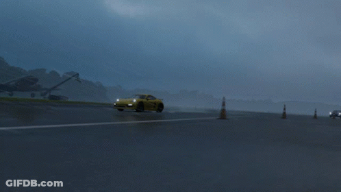 A Yellow Sports Car Is Driving On A Wet Road GIF